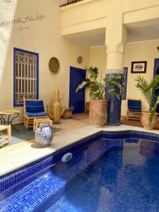 Riad Hotel Sherazade في مراكش: بيت فيه مسبح بأبواب زرقاء