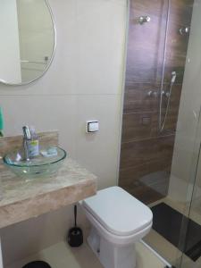 y baño con aseo, lavabo y ducha. en Casa aconchegante com lareira en Campos do Jordão