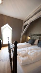 ein Schlafzimmer mit einem großen Bett und einem großen Fenster in der Unterkunft Boutiquehotel Kloster Pfalzel in Trier