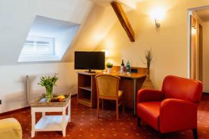 a living room with a desk with a tv and a chair at Wohnen am Schloss, Schlossblick in Sondershausen