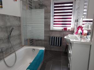a bathroom with a bath tub and a sink at Ferienwohnung Mahlsdorf in Berlin +24 photos