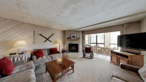 a living room with a couch and a fireplace at Slopeside 1849 Condos - Comfortable 3 BR Condos with Full Kitchens in Mammoth Lakes