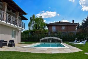 una piscina in un cortile accanto a una casa di Il Riccio e la Castagna - Country House a Montaldo Roero