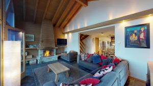 een woonkamer met een bank en een open haard bij Natasha EXCEPTIONAL & LUXE chalet 12 pers by Alpvision Résidences in Plan Fey