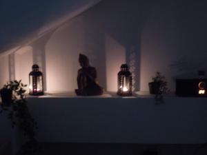 een donkere kamer met kaarsen en verlichting op een plank bij FERTILE in Charleroi