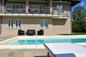 una casa con piscina di fronte a una casa di Il Riccio e la Castagna - Country House a Montaldo Roero