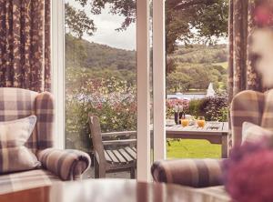 a room with a view of a patio with a table at Lakeside Hotel and Spa in Newby Bridge