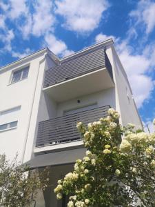 - un bâtiment blanc avec balcon et ciel bleu dans l'établissement Apartments Tanja, à Kaštela