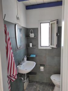 a bathroom with a sink and a toilet and a window at Malli Sea House in Mamádhos