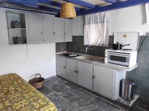 a kitchen with white cabinets and a microwave on a counter at Malli Sea House in Mamádhos