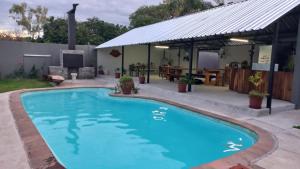 a swimming pool in a backyard with a gazebo at Urban Farm Haus Guesthouse in Rundu