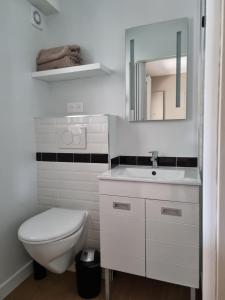 La salle de bains est pourvue de toilettes, d'un lavabo et d'un miroir. dans l'établissement Le Prevet, à Saint-Malo