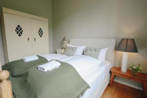 1 dormitorio con 2 camas con sábanas blancas y lámpara en Boutiquehotel Kloster Pfalzel, en Trier