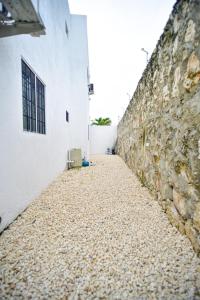 an alley with a stone wall next to a building at Acogedora casa en Punta Cana Amueblada in Punta Cana
