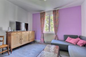 a living room with purple walls and a blue couch at "Urbaine Colors" Appartement coloré et lumineux "Les Péri-Urbaines" in Riedisheim