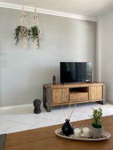 a living room with a flat screen tv on a wooden entertainment center at Blue View Seaside Luxury Apartments in Ixia