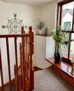 a room with a staircase and a vase with flowers in it at The Smiddy in Inverness