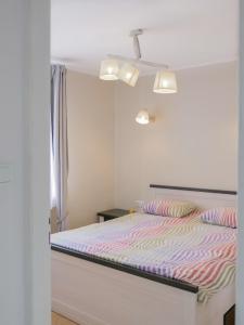 ソポトにあるApartament Bursztynowyのベッドルーム1室(ストライプ掛け布団付きのベッド1台付)