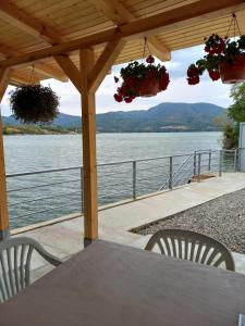 Una mesa y sillas con vista al agua. en Casa din Golful Dunării, en Eşelniţa