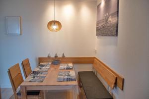 - une salle à manger avec une table en bois et un éclairage dans l'établissement Ferienwohnung-MAJA-in-Sassnitz-fuer-2-Erwachsene-und-1-Kind-oder-3-Erwachsene, à Sassnitz