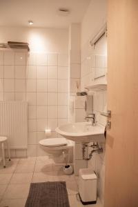 een witte badkamer met een wastafel en een toilet bij Ferienwohnung-MAJA-in-Sassnitz-fuer-2-Erwachsene-und-1-Kind-oder-3-Erwachsene in Sassnitz
