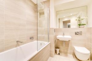 a bathroom with a tub and a sink and a toilet at The Butler Suite in York