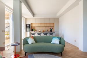 a living room with a green couch and a kitchen at Lunam Penthouse in centre in Lucca