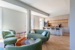 a living room with two chairs and a kitchen at Lunam Penthouse in centre in Lucca