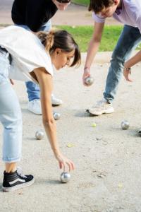 a group of people playing with balls on the ground at Hotel Demeures de Campagne Château de Fontainebleau in Fontainebleau