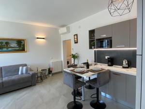 a kitchen and living room with a table and a couch at Relaxing Home in Tignale