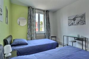 a bedroom with two beds and a window at "Urbaine Colors" Appartement coloré et lumineux "Les Péri-Urbaines" in Riedisheim