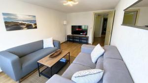 Holiday Apartments Falke في برينز: غرفة معيشة مع أريكة وتلفزيون