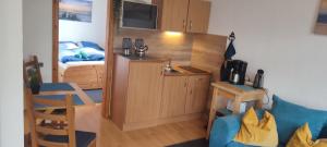 a small room with a bed and a blue couch at Ankerplatz, Am Hafen Ost 10 in Carolinensiel