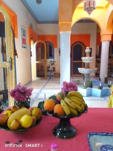 a table with two plates of fruit on a table at Riad De Rêve in Zagora