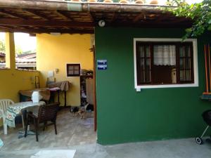 una pared verde con ventana y un perro en una habitación en Studio Tipo Chale PRAIA SANTA TEREZA, en Ilhabela