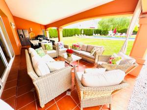 a patio with wicker chairs and couches and a table at VILLA SOL Y LUNA Mediterránea in Alhaurín de la Torre