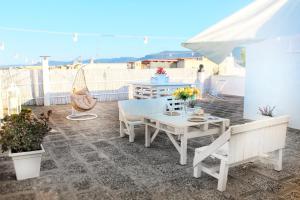 eine Terrasse mit einem Tisch, Stühlen und einem Sonnenschirm in der Unterkunft De Mola Holiday House in Pezze di Greco
