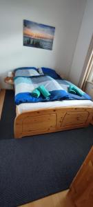 łóżko z drewnianą ramą w pokoju w obiekcie Ankerplatz, Am Hafen Ost 10 w mieście Carolinensiel
