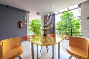 a dining room with a glass table and two chairs at Barista Hotel in Uttaradit