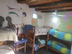 1 dormitorio con 2 literas y un mural en Eco Hostel Valle Fertil en San Agustín de Valle Fértil