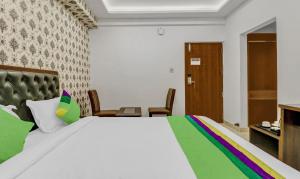 a bedroom with a large bed with a rainbow blanket at Treebo Trend Three Drops in Bangalore