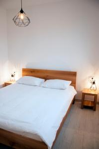 um quarto com uma grande cama branca e 2 candeeiros em Haus Cvita em Ražanac