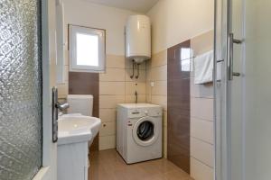 uma casa de banho com uma máquina de lavar roupa e um lavatório em Haus Perkovic em Ražanac