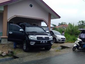 Ein schwarzer Truck parkt vor einem Haus. in der Unterkunft Zahra Syariah Home Stay in Bukittinggi