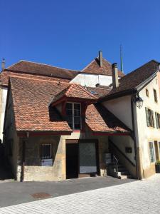 een oud gebouw met een bruin dak bij Charmante maison VintageCorner in Saint-Blaise