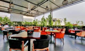 un restaurant vide avec des tables, des chaises et un écran dans l'établissement Treebo Trend Three Drops, à Bangalore