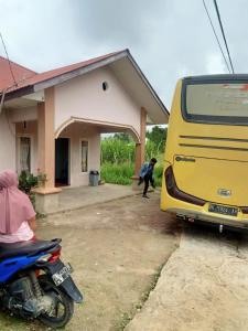 ein gelber Bus, der vor einem Haus parkt in der Unterkunft Zahra Syariah Home Stay in Bukittinggi