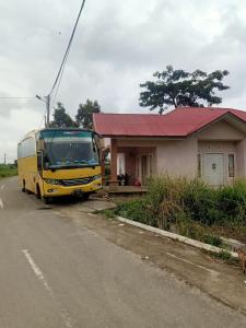 een gele bus geparkeerd voor een huis bij Zahra Syariah Home Stay in Bukittinggi
