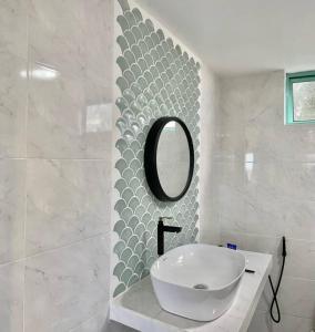 Un baño blanco con lavabo y espejo. en Sea Kecil Tiny House near Jetty of Kuala Besut, en Kampong Nail 15 fotos más