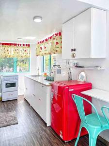 a kitchen with a red refrigerator and a green chair at Sea Kecil Tiny House near Jetty of Kuala Besut in Kampong Nail